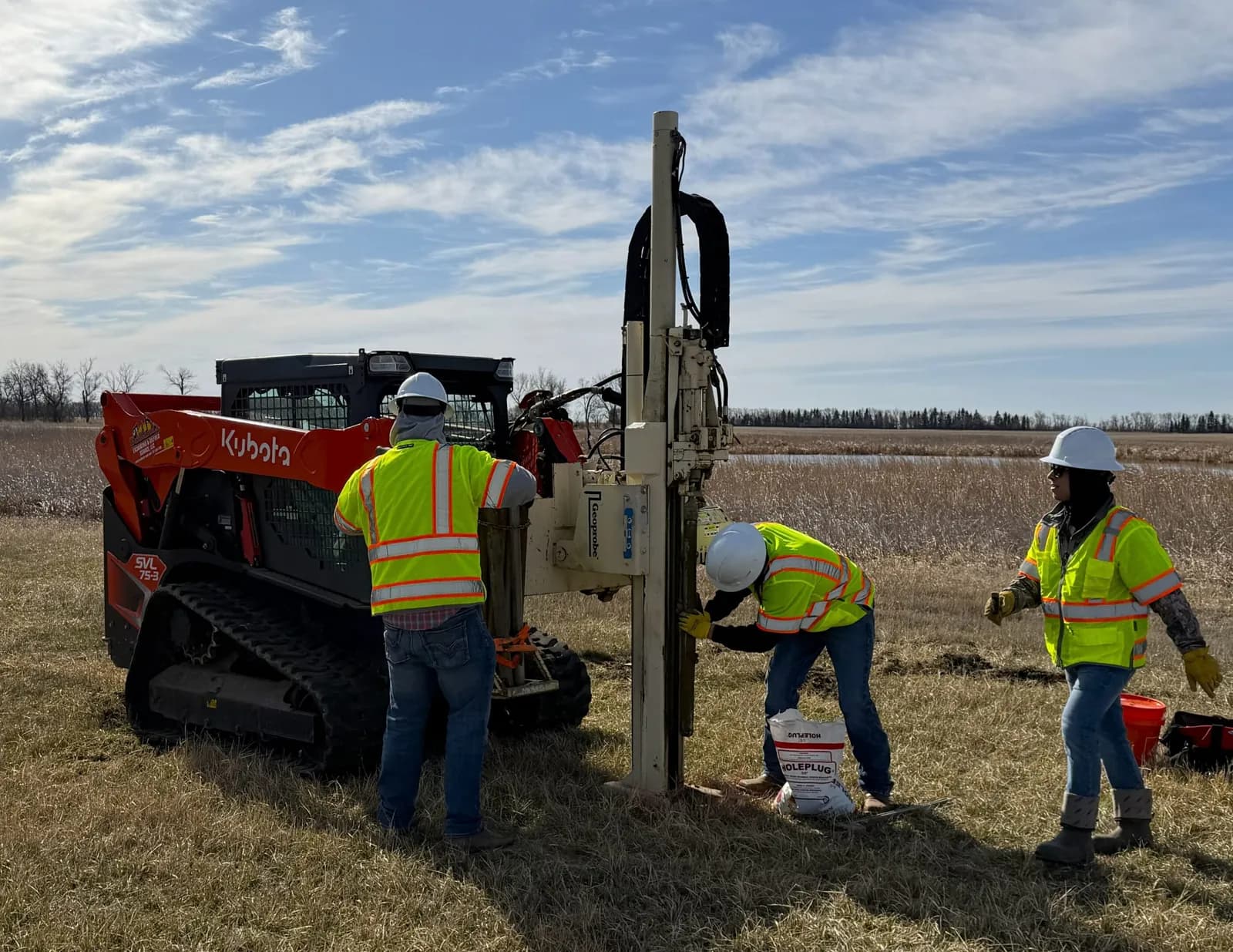 Summit crew taking soil samples with a track-mounted probe rig