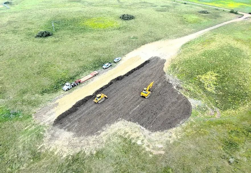 Aerial view of the excavation at MRPSU 36-21 North, cut into flowering canola.