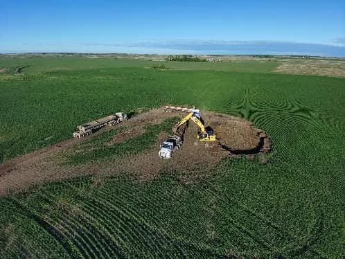 Aerial view of the excavation at Schwartz 1, cut into standing green wheat.