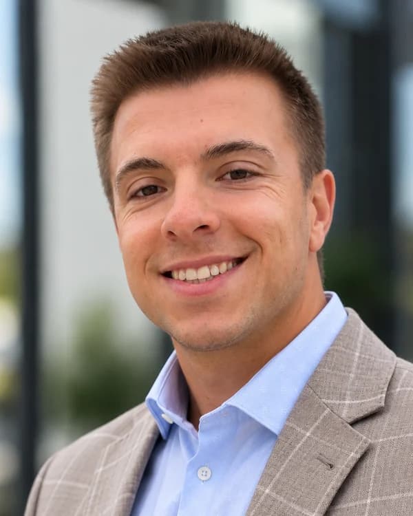 Portrait of Chris Gidley in a light plaid blazer and blue shirt