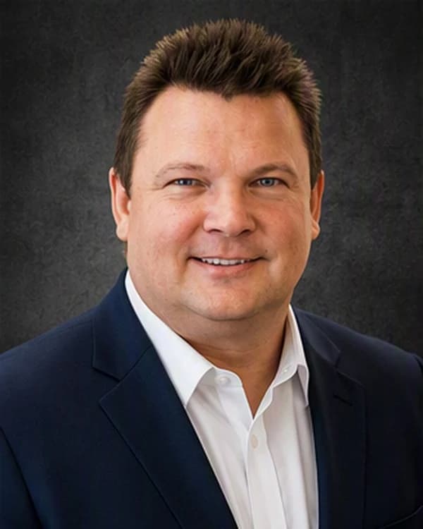 Portrait of Jon Ellingson in a navy suit and open-collar white shirt